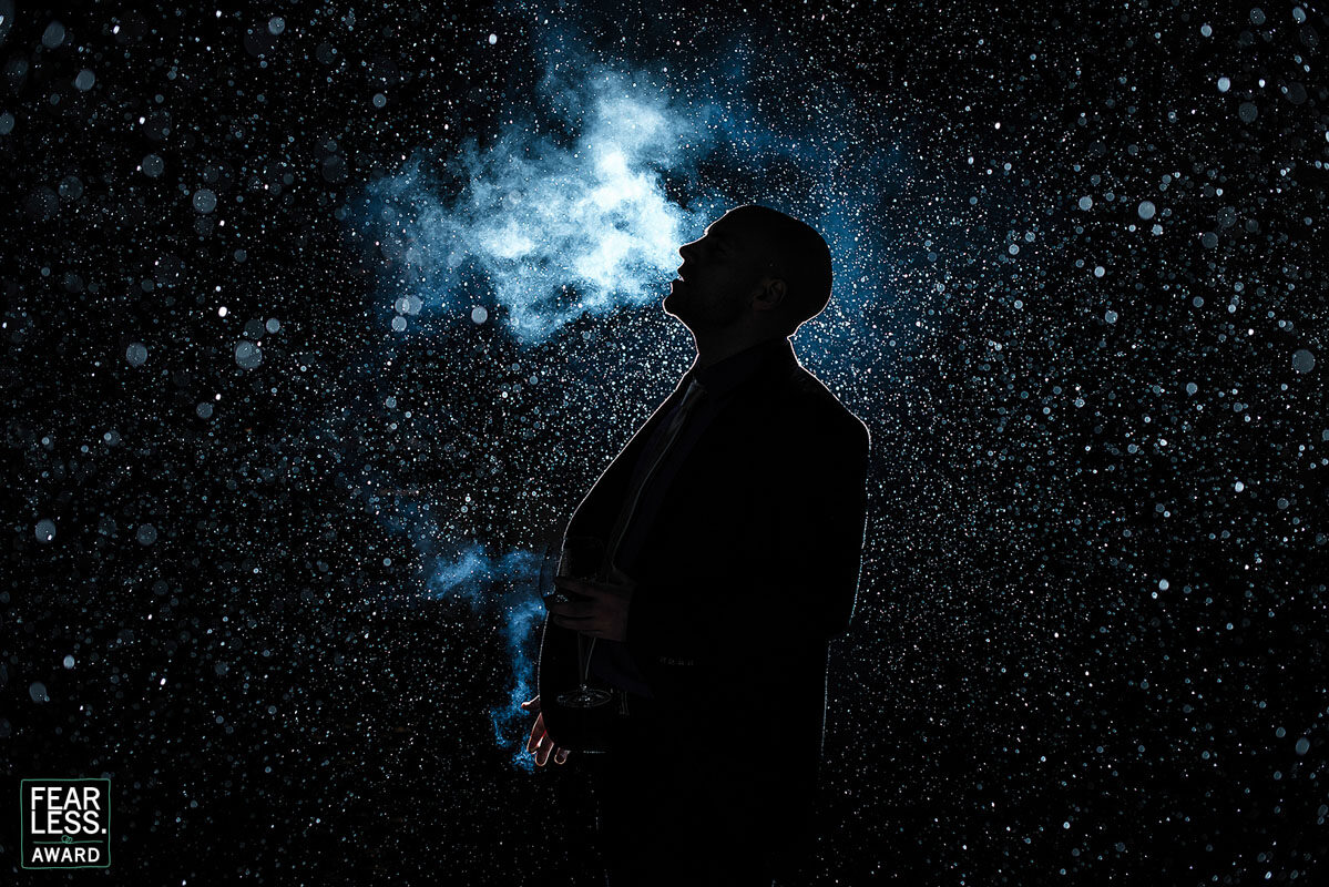 Silhouette mit Rauchwolke vor glitzerndem Hintergrund — Fearless Award