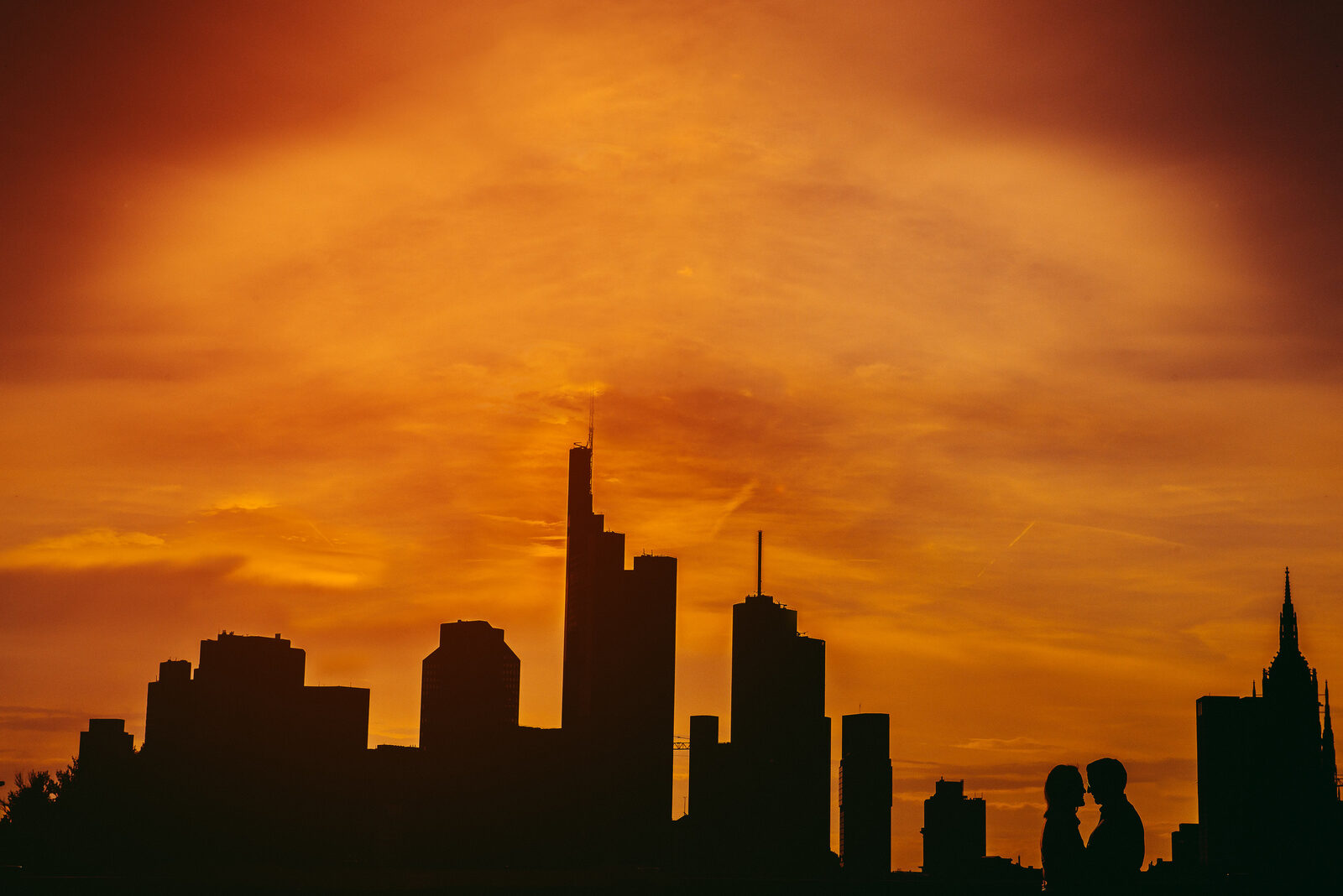 Paar als Silhouette vor der Frankfurter Skyline im Abendrot
