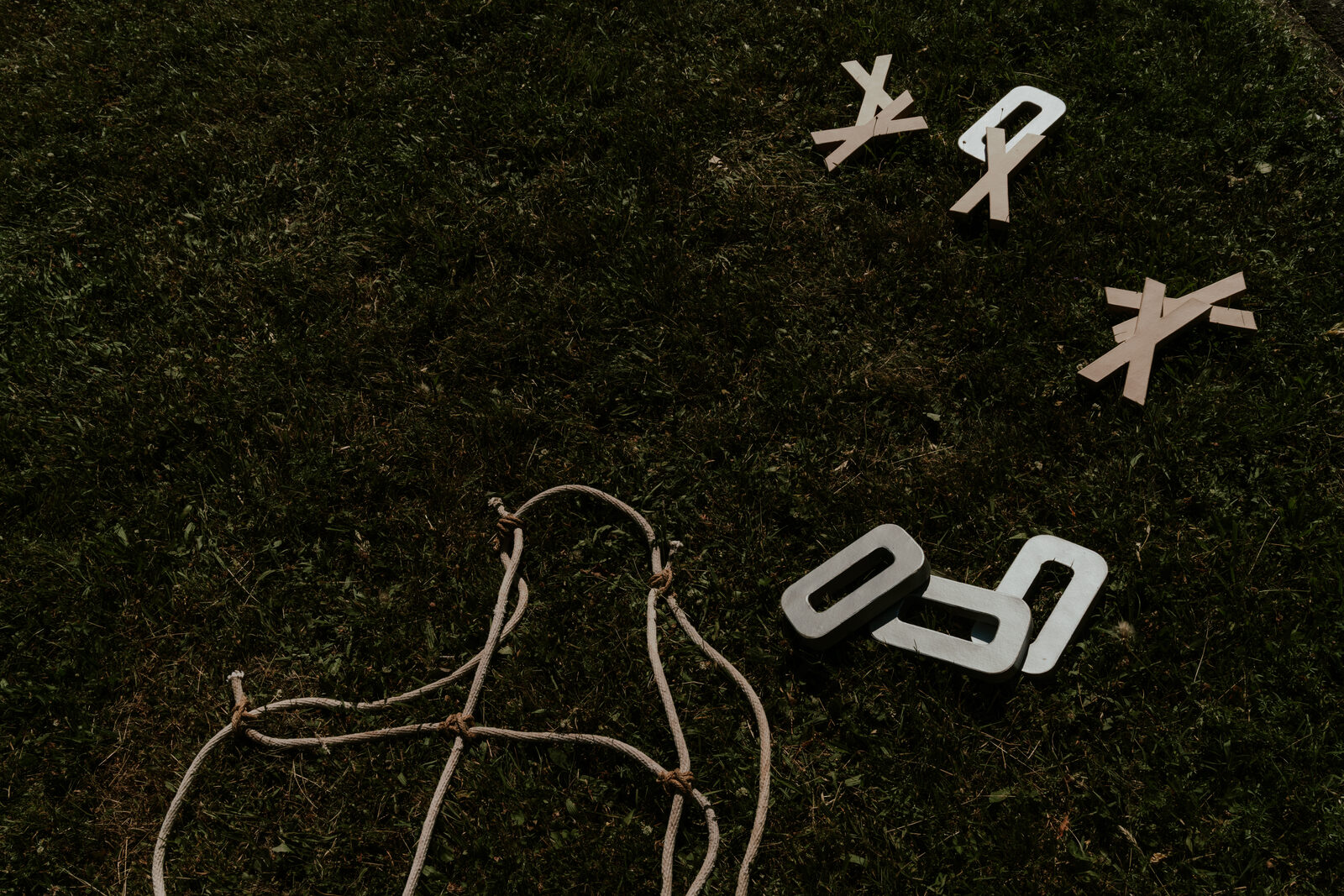 Buchstaben und ein Herz aus Draht liegen im Gras