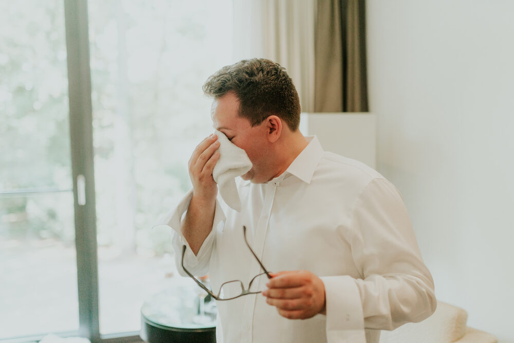 Der Bräutigam nimmt sich einen Moment für sich, die Brille in der Hand
