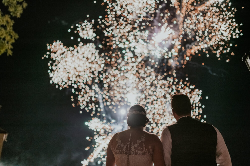 Das Brautpaar schaut dem Feuerwerk über der Burg zu